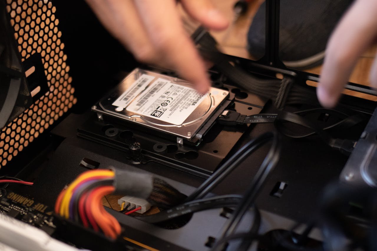 Home Hands installing a hard drive in a computer case, emphasizing technology and connectivity.
