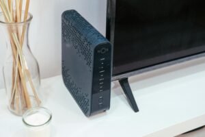 A sleek home technology setup featuring a router, glass decoration, and television.